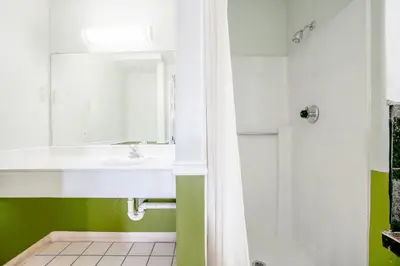 a bathroom with a white sink and a shower at Day & Night Inn in Hesperia
