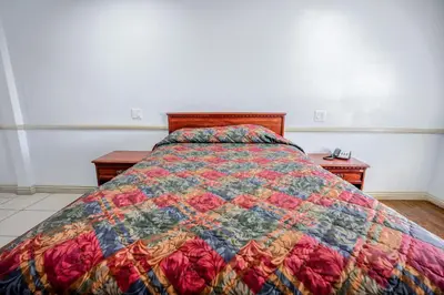 a bedroom with a bed with a quilt on it at Day & Night Inn in Hesperia