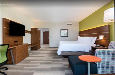 a hotel room with a bed and a flat screen tv at Holiday Inn Express & Suites Santa Ana - Orange County by IHG in Santa Ana