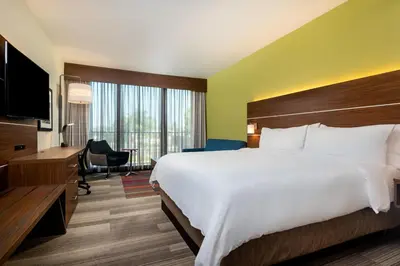a hotel room with a large bed and a desk at Holiday Inn Express & Suites Santa Ana - Orange County by IHG in Santa Ana