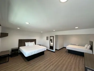 a hotel room with two beds and a desk at Hyland Inn Van Nuys in Van Nuys