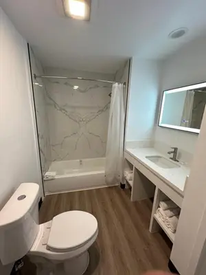 a bathroom with a shower and a toilet and a sink at Hyland Inn Van Nuys in Van Nuys