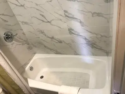 a shower with a white tub in a bathroom at Hyland Inn Brea in Brea
