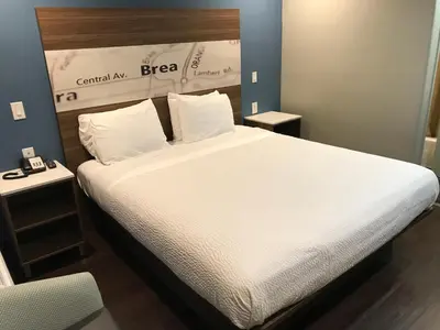 a bedroom with a large bed with white sheets and pillows at Hyland Inn Brea in Brea