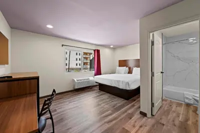 a hotel room with a bed and a bathroom at Hyland Inn Long Beach in Long Beach