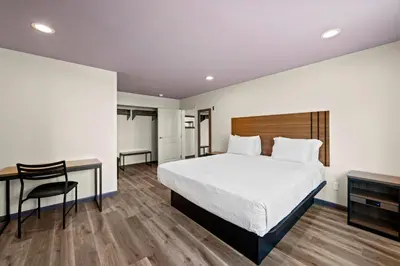 a hotel room with a bed and a desk and a bed at Hyland Inn Long Beach in Long Beach