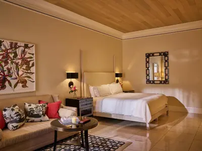 a bedroom with a bed and a couch at Hotel Bel-Air - Dorchester Collection in Los Angeles