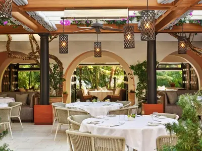 an outdoor restaurant with white tables and chairs at Hotel Bel-Air - Dorchester Collection in Los Angeles