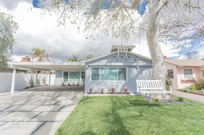 a white house with a tree in the yard at Enchanting Sherman Oaks Home With Pool permit #HSR two five zero zero 3222 in Sherman Oaks