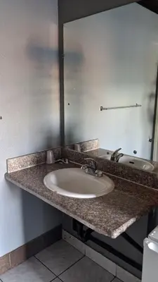 a bathroom counter with a sink and a mirror at Eagle Inn Motel in Long Beach