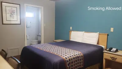 a hotel room with a bed and a bathroom at Eagle Inn Motel in Long Beach
