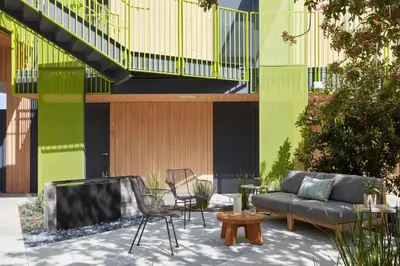 a patio with a couch and chairs in front of a building at Mayumi in Los Angeles