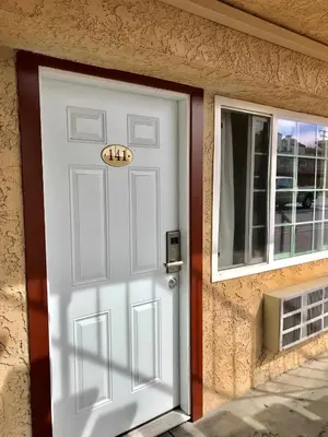 a white door with a sign on it next to a window at norwalk inn & suites in Norwalk