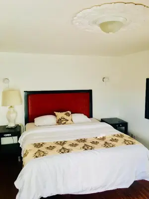 a bedroom with a large bed with a red headboard at norwalk inn & suites in Norwalk