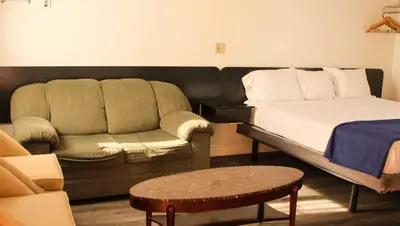 a living room with a bed and a couch at Motel 6 Glendale CA Pasadena Burbank Los Angeles in Glendale