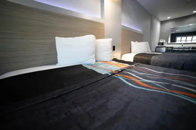 a hotel room with two beds in a room at Travelodge by Wyndham Whittier in Whittier