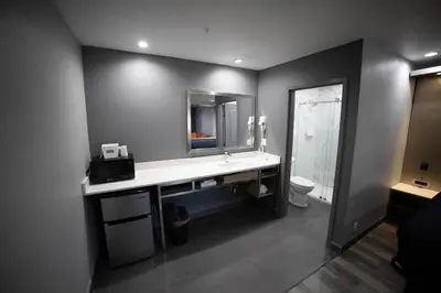 a bathroom with a sink and a mirror and a toilet at Travelodge by Wyndham Whittier in Whittier