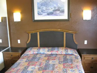 a bedroom with a bed with a quilt on it at Sunshine Motel in San Bernardino