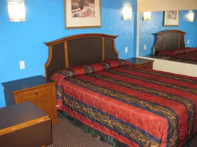a hotel room with a bed and a mirror at Sunshine Motel in San Bernardino