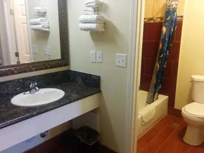 a bathroom with a sink and a toilet and a mirror at Sunshine Motel in San Bernardino