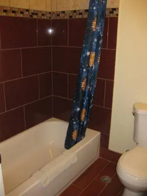 a bathroom with a toilet and a bath tub at Sunshine Motel in San Bernardino