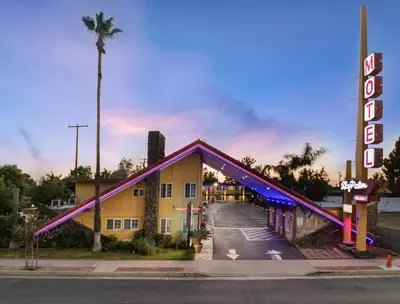 a hotel with a sign on the side of a road at Sky Palm Motel - Orange in Orange