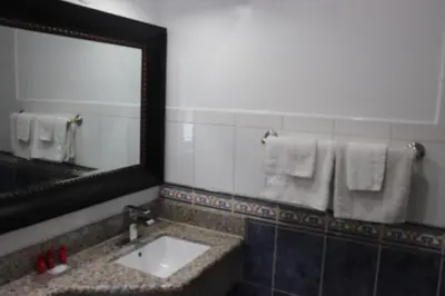a bathroom with a sink and a mirror and towels at El Dorado Motel in Gardena