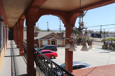 a balcony with a red car parked in a parking lot at El Dorado Motel in Gardena