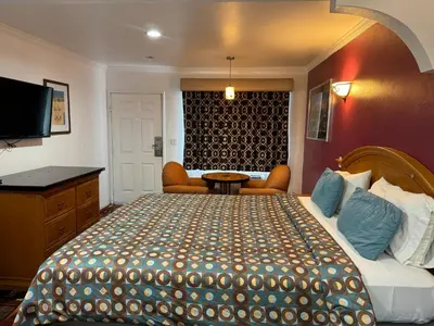 a hotel room with a large bed and a tv at El Dorado Motel in Gardena