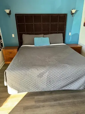 a bedroom with a large bed with a blue wall at El Dorado Motel in Gardena