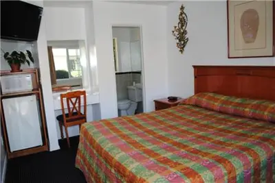 a hotel room with a bed and a bathroom at Rose Bowl Motel in Los Angeles
