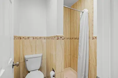 a bathroom with a toilet and a shower at Rodeway Inn Commerce - Los Angeles in Commerce
