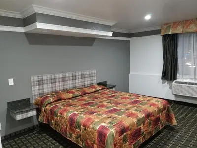 a bedroom with a large bed in a room at Rodeway Inn Commerce - Los Angeles in Commerce
