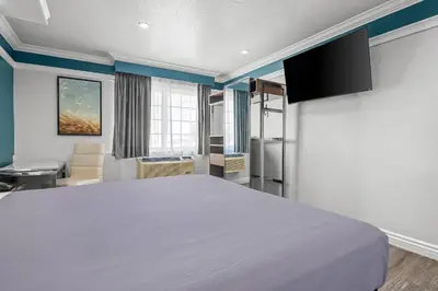 a bedroom with a large white bed in a room at Rodeway Inn Commerce - Los Angeles in Commerce