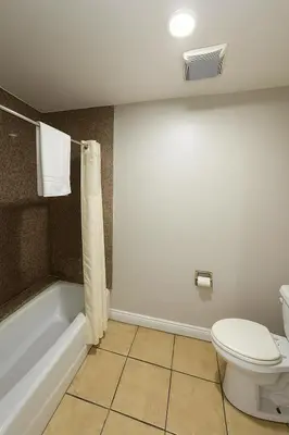a bathroom with a toilet and a bath tub at Sand Piper Motel - Los Angeles in Los Angeles