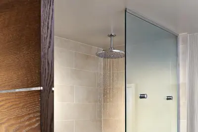 a bathroom with a shower with a glass door at The Anza-a Calabasas Hotel in Calabasas