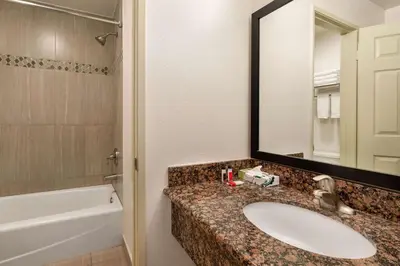 a bathroom with a sink and a tub and a mirror at Super 8 by Wyndham Santa Clarita/Valencia in Santa Clarita