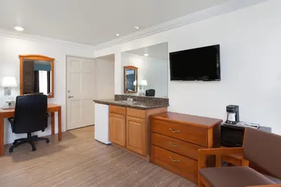 a hotel room with a desk and a television at Super 8 by Wyndham Santa Clarita/Valencia in Santa Clarita