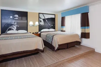 a hotel room with two beds and a motorcycle at Super 8 by Wyndham Santa Clarita/Valencia in Santa Clarita