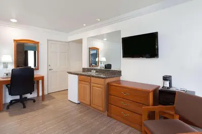 a hotel room with a desk and a flat screen tv at Super 8 by Wyndham Santa Clarita/Valencia in Santa Clarita