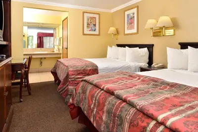 a hotel room with two beds and a television at Americas Best Value Inn Pasadena in Pasadena