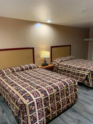 a hotel room with two beds and a lamp at Budget Inn Motel in San Gabriel