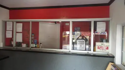 a store front window with a red wall at Budget Inn Motel in San Gabriel
