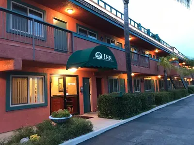 a inn with an umbrella on the side of a building at Oakridge Inn in Oak View