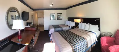 a hotel room with two beds and a living room at Oakridge Inn in Oak View