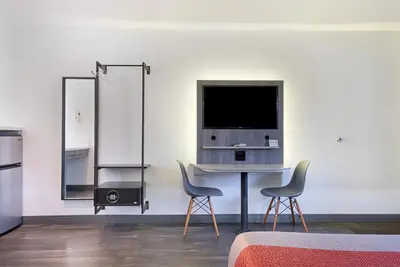 a room with two chairs and a table with a television at Solo Motel Broadway in Los Angeles