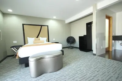 a bedroom with a bed and a chair in it at Grandview Inn in Hermosa Beach