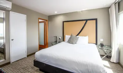 a bedroom with a large white bed and a window at Grandview Inn in Hermosa Beach