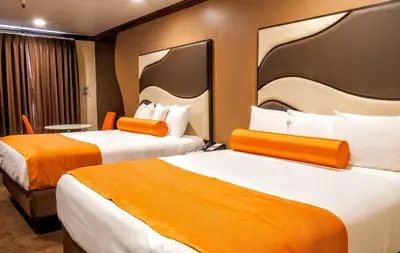 two beds in a hotel room with orange accents at Redondo Pier Inn in Redondo Beach