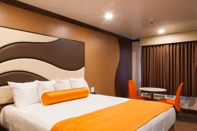 a hotel room with a large bed with an orange headboard at Redondo Pier Inn in Redondo Beach